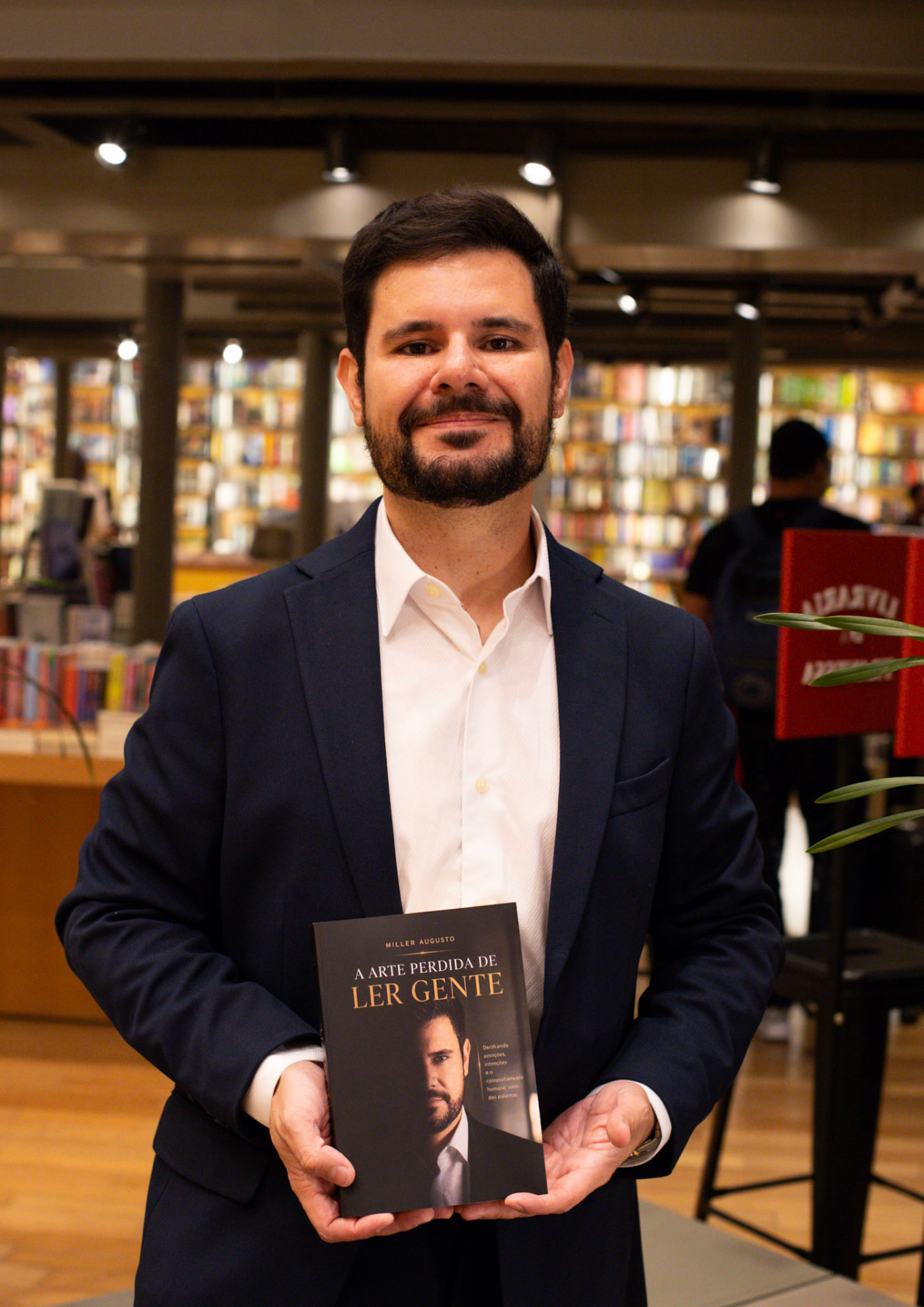 Miller Augusto segurando seu livro na noite de autógrafos